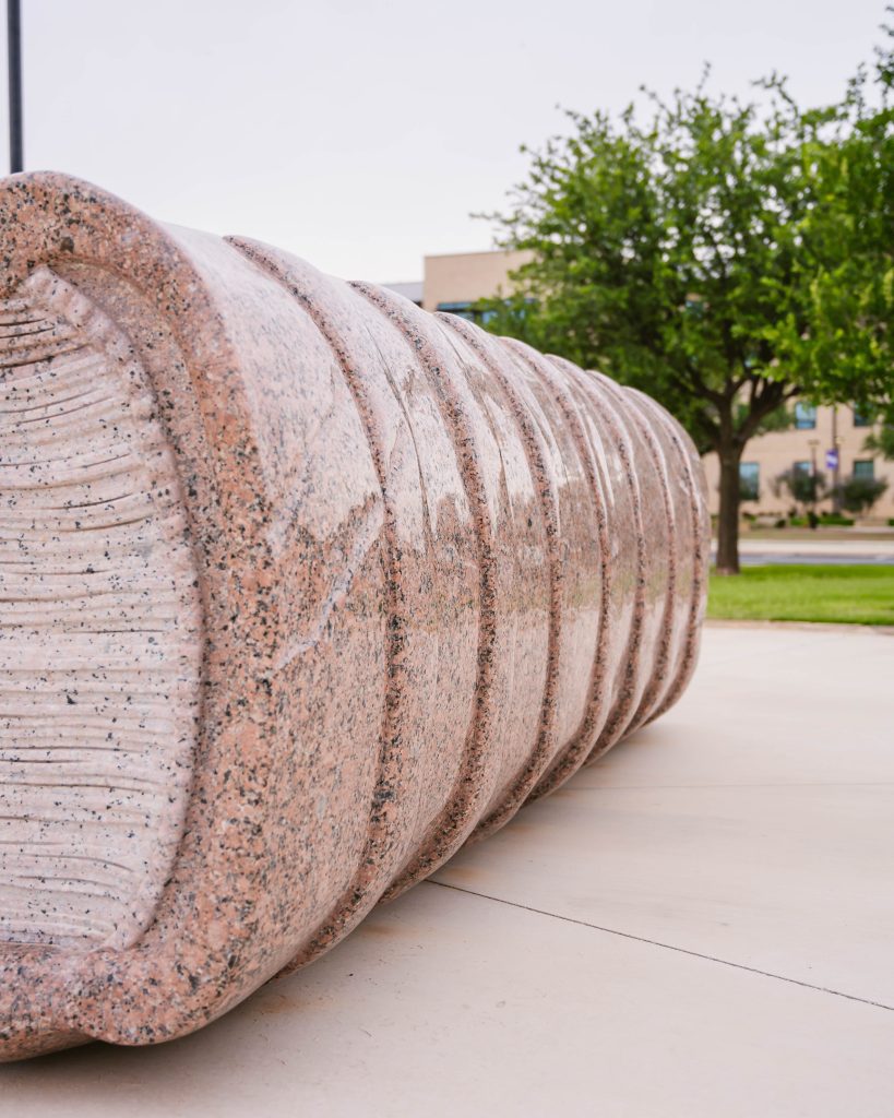 Close-up of The Book natural stone sculpture at Abilene Christian University, highlighting the carved spine detail and craftsmanship of the stone design.