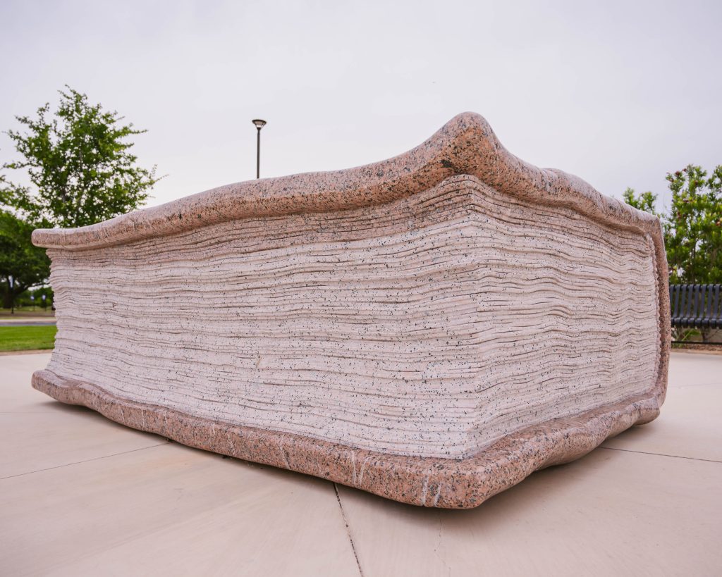 Natural stone book sculpture featuring carved page details at Abilene Christian University.